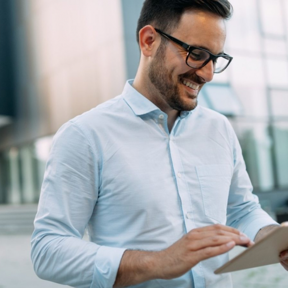 portrait-of-businessman-in-glasses-holding-tablet-AWVHCJU-1600x900