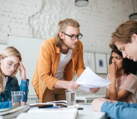 group-of-upset-students-sitting-at-the-table-with-E5YW9L4